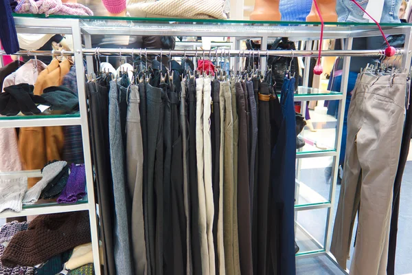 Shop pants different group colored jeans hanging on a hanger in — Stock Photo, Image