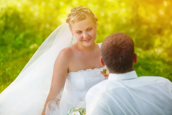 Sunlight Bride looking at groom wedding couple on a green backgr — стоковое фото