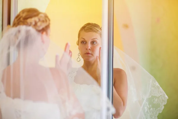 Noiva luz solar olha no espelho no dia do casamento — Fotografia de Stock