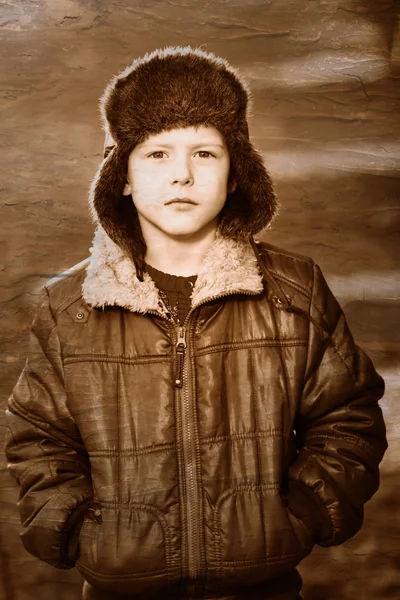 Ретро черно-белая фотография мальчика Сепия в коричневой куртке и мехе — стоковое фото