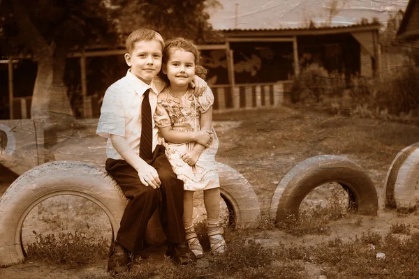 Retro black and white photo of sepia boy and girl children sitti — Stock Photo, Image