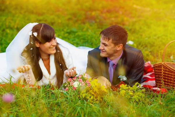 Sunlight bride and groom at picnic in autumn are couple on green — Stock Photo, Image