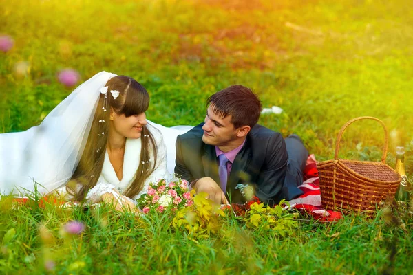 Sunlight bride and groom at picnic in autumn are couple on green — Stock Photo, Image