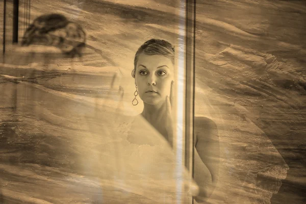 Retro sepia zwart / wit foto, bruid kijkt in de spiegel in — Stockfoto