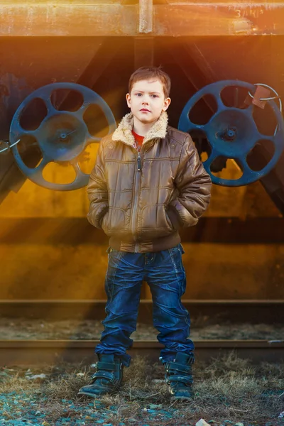 Solljus pojke blondin tramp i en brun jacka, skrynkliga jeans på t — Stockfoto