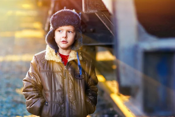 Solljus pojke hemlös uteliggare på gatan frysning nära järnvägen ca — Stockfoto