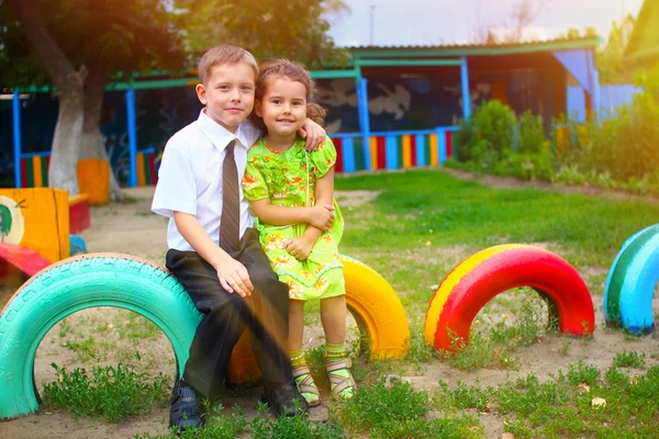 Sunlight boy and girl children sitting outdoors in courtyard of — Stock Photo, Image