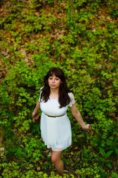 Top view of young brunette woman in white dress standing on gree — Stock Photo, Image