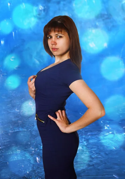 Beautiful brunette woman blue dress stands sideways — Stock Photo, Image