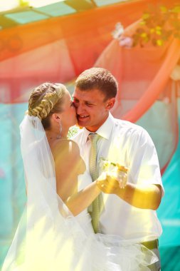 Çift güneş ışığı sarı gelin ve damat öpüşme yeni evliler başlayay üzerinde