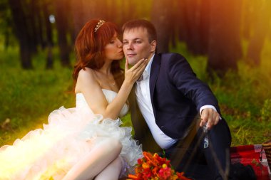 güneş ışığına gelin ve damat yeşil çimenlerin üzerinde oturan çift, ben piknik