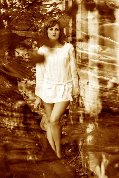 Retro sepia photo curly-haired girl with bare legs in a white sh — Stock Photo, Image