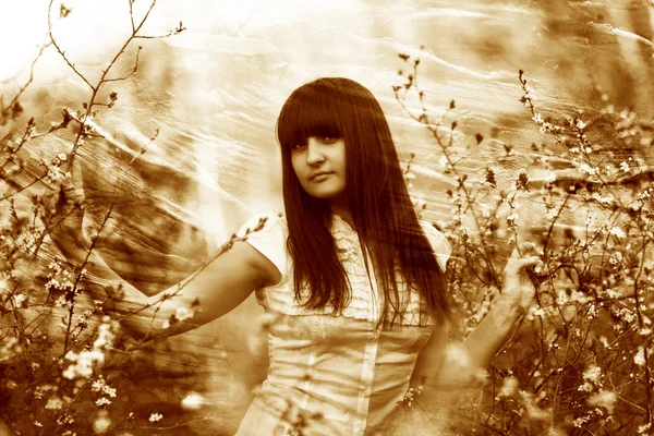 Retro sépia foto menina primavera segurando um ramo de flor de cereja — Fotografia de Stock