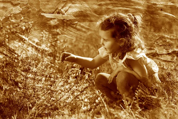 Retro sepia photo, little baby girl studying touching look yello — Stock Photo, Image