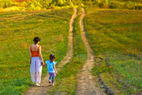 Mutter Frau kleines Mädchen meine Tochter gehen auf der Landstraße durch gr — Stockfoto