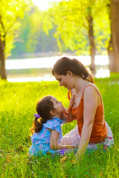 Mor dotter flicka och kvinna sitter på grönt gräs natur — Stockfoto