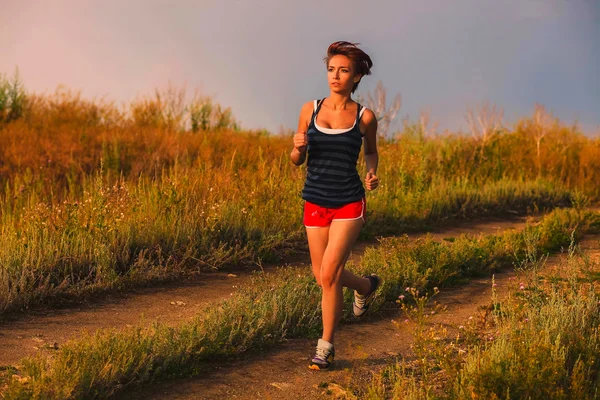 Krásné zdravé běží mladá bruneta žena za atleta službou ou — Stock fotografie