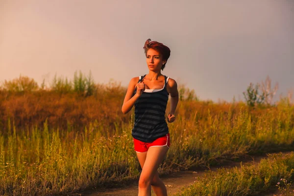 Bella una sana corre giovane donna bruna atleta in esecuzione ou — Foto Stock