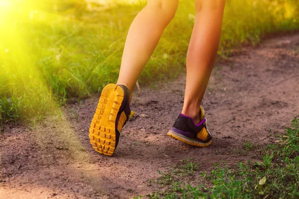 A luz solar ostenta um sapatos femininos grandes pernas correndo, exercendo um — Fotografia de Stock