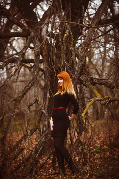 Red-haired woman in dark forest — Stock Photo, Image