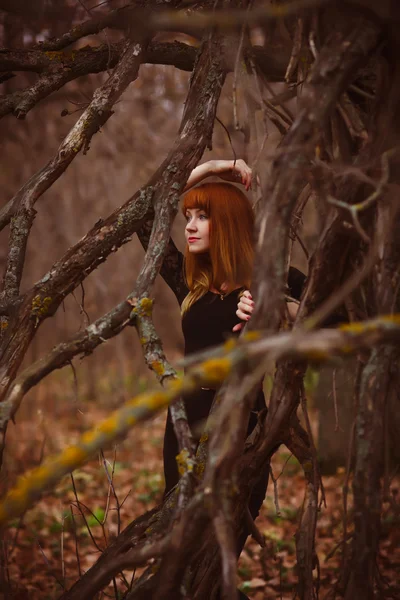 Chica pelirroja modelo mujer en vestido negro seco otoño oscuro — Foto de Stock