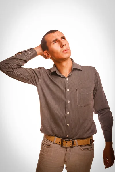 Man thinks brunette looking up scratching his head studio — Stock Photo, Image