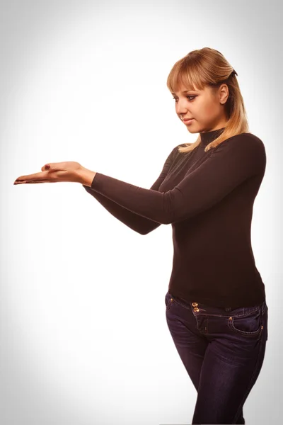 Porträtt glad ung blond kvinna visar öppen hand hålla svart — Stockfoto