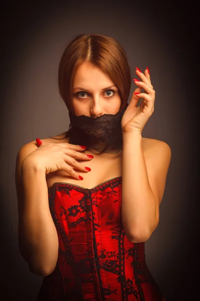 Mujer chica en corsé rojo, su boca cubierta — Foto de Stock