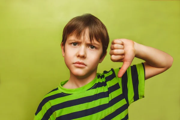 Baby boy showing teenager thumbs down on the big green backgroun — Stock Photo, Image