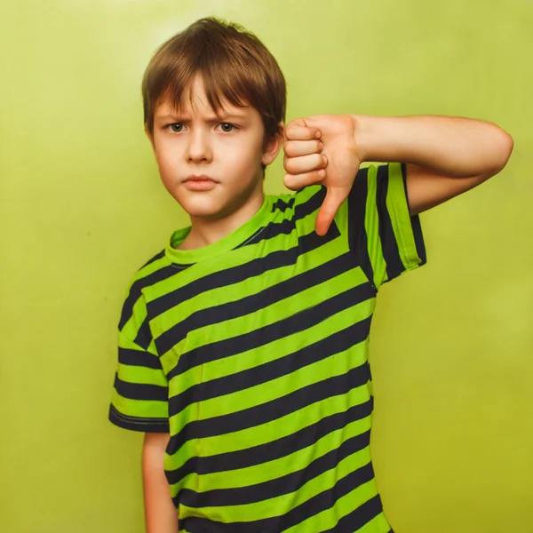 大きな緑色の背景にダウン親指を示す男の子 10 代 — ストック写真