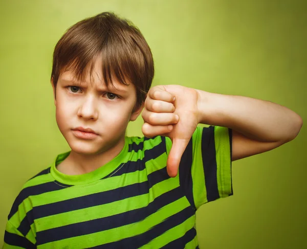 Chłopiec dziecko nastolatek Wyświetlono kciuk w dół na duży zielony deseń — Zdjęcie stockowe