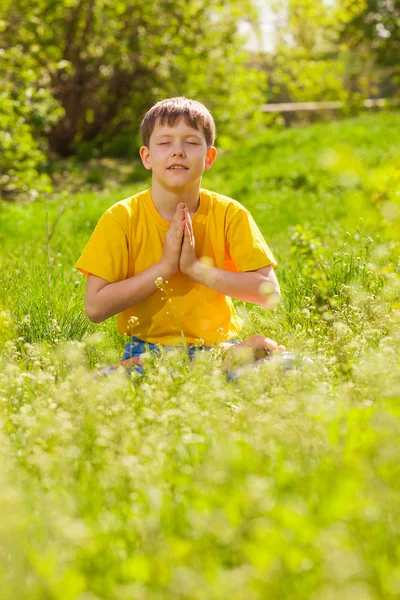 Blonde teen boy in lotus position meditating, meditation on natu — Stock Photo, Image