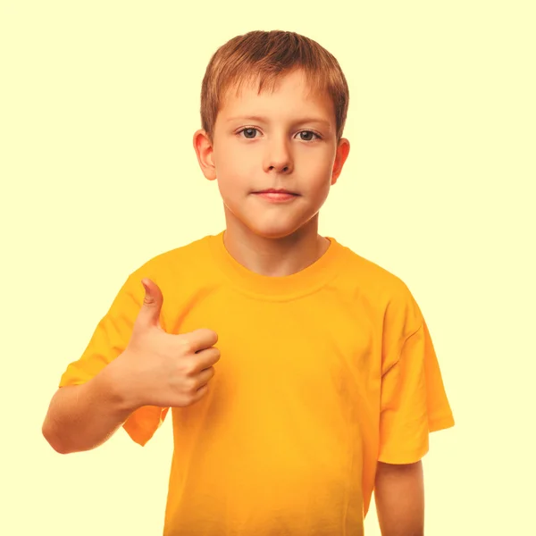 Blond boy kid in a yellow shirt holding a thumbs-up, showing the — Stock Photo, Image