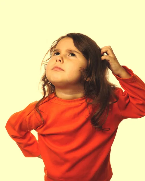 Angry evil child curly girl in orange sweater angry isolated on — Stock Photo, Image