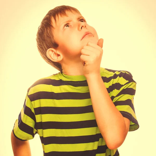 Child boy teen blonde in striped T-shirt scratching his head loo — Stock Photo, Image