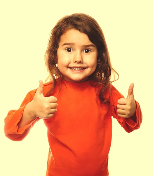 Little brunette child curly girl in an orange jacket, showing tw — Stock Photo, Image