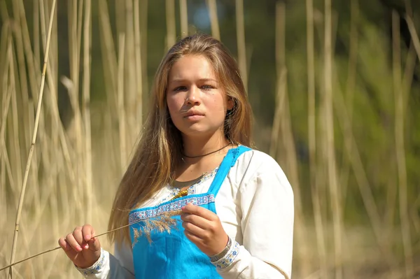 Girl in a blue sundress in a field of tall dry grass — Stock Photo, Image