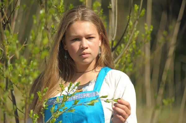 Chica en un vestido azul en un campo de hierba seca alta — Foto de Stock