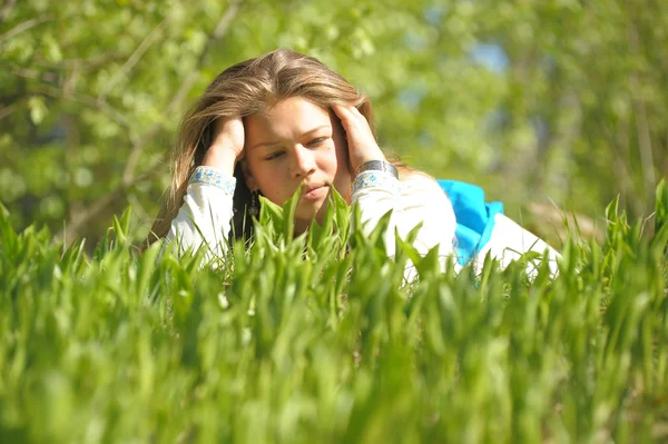 Молодая женщина лежит на зеленой траве — стоковое фото