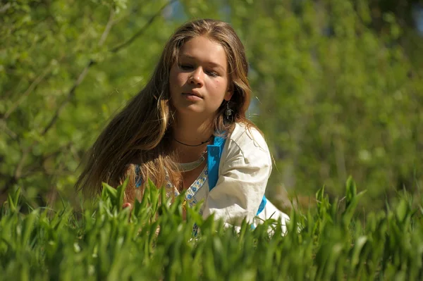 Jeune femme couchée sur l'herbe verte — Photo