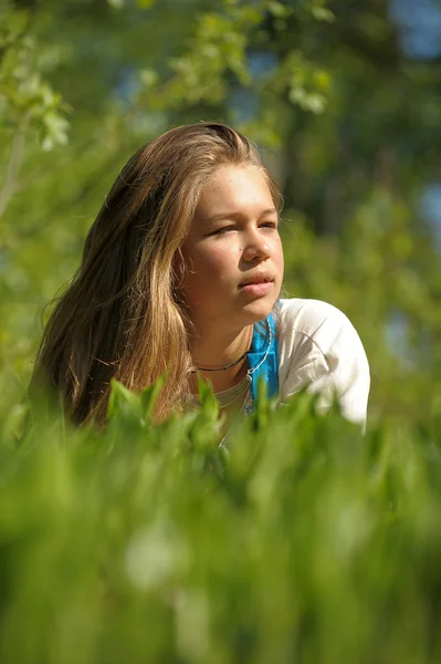 Genç kadın yeşil çim üzerinde yalan — Stok fotoğraf