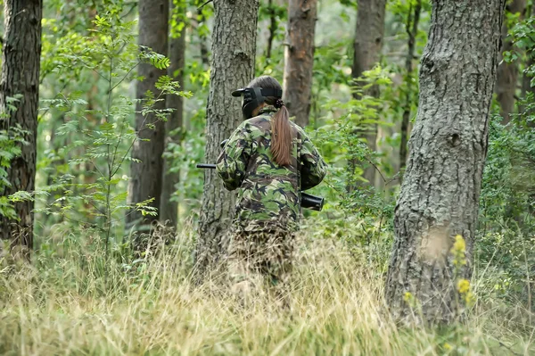 Meisje in camouflage kleding in het bos — Stockfoto