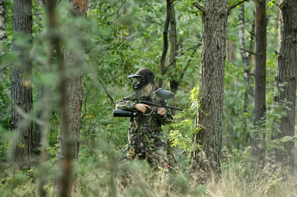 Meisje in camouflage kleding in het bos — Stockfoto