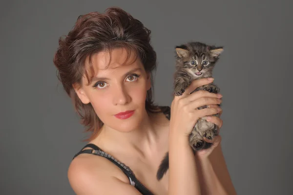 Retrato de uma jovem mulher com um gatinho nas mãos — Fotografia de Stock