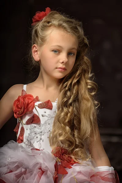 Blond meisje in een slimme wit met een rode jurk — Stockfoto