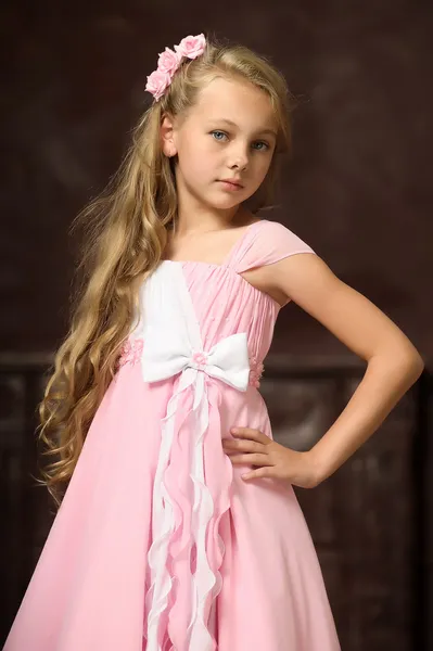 Menina loira bonita com cabelos longos em um vestido de princesa rosa . — Fotografia de Stock