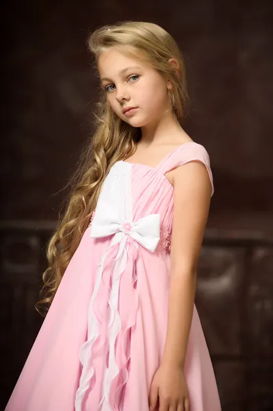 Hermosa joven rubia con el pelo largo en un vestido de princesa rosa . — Foto de Stock