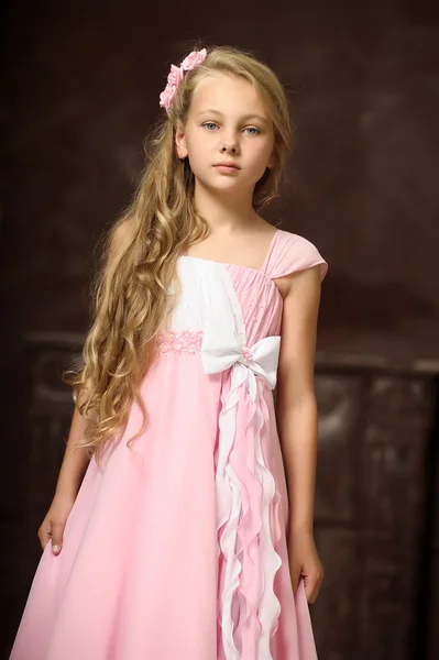 Beautiful young blonde girl with long hair in a pink princess dress. — Stock Photo, Image