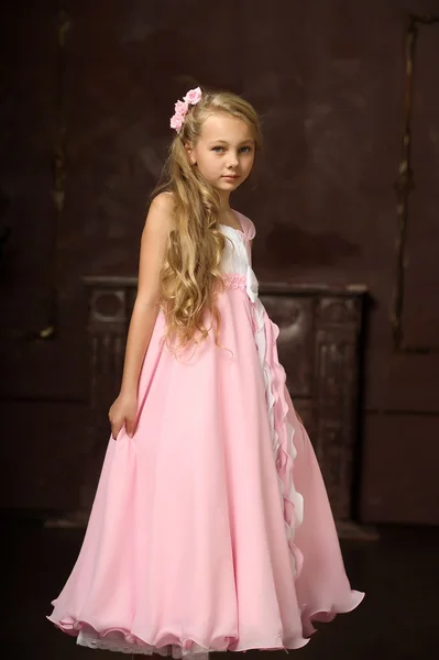 Menina loira bonita com cabelos longos em um vestido de princesa rosa . — Fotografia de Stock