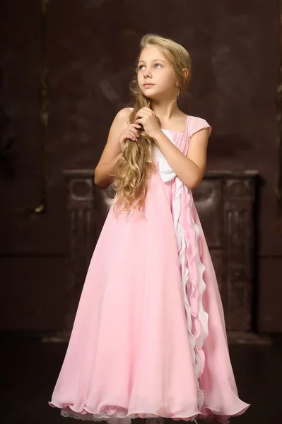 Menina loira bonita com cabelos longos em um vestido de princesa rosa . — Fotografia de Stock